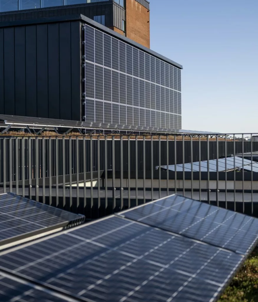 Solpaneler installerade på en byggnad under en klar blå himmel.