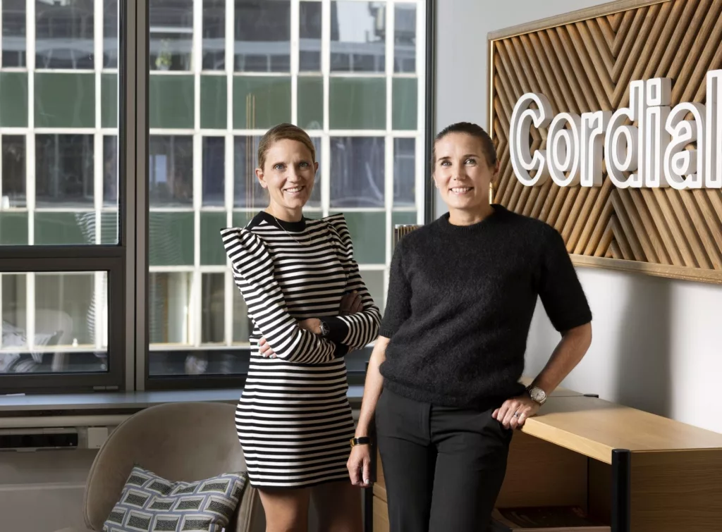 Två personer står framför ett fönster i ett kontor med en skylt som lyder "Cordo".