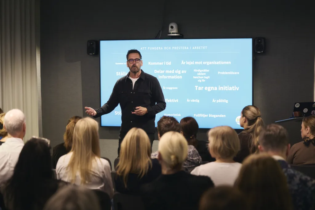 Johan Book står framför en skärm och föreläser för publik på Arena Sergel.