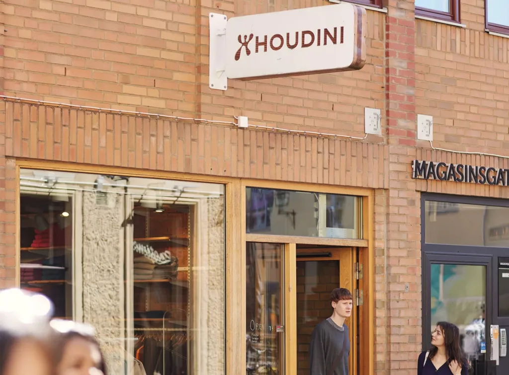 Houdini-butikens fasad i tegel med skylt och personer som passerar utanför.