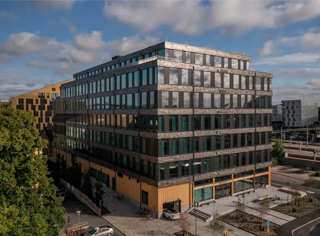 5. Ett stort kontorshus med blandad tegel- och glasfasad, beläget i en urban miljö.