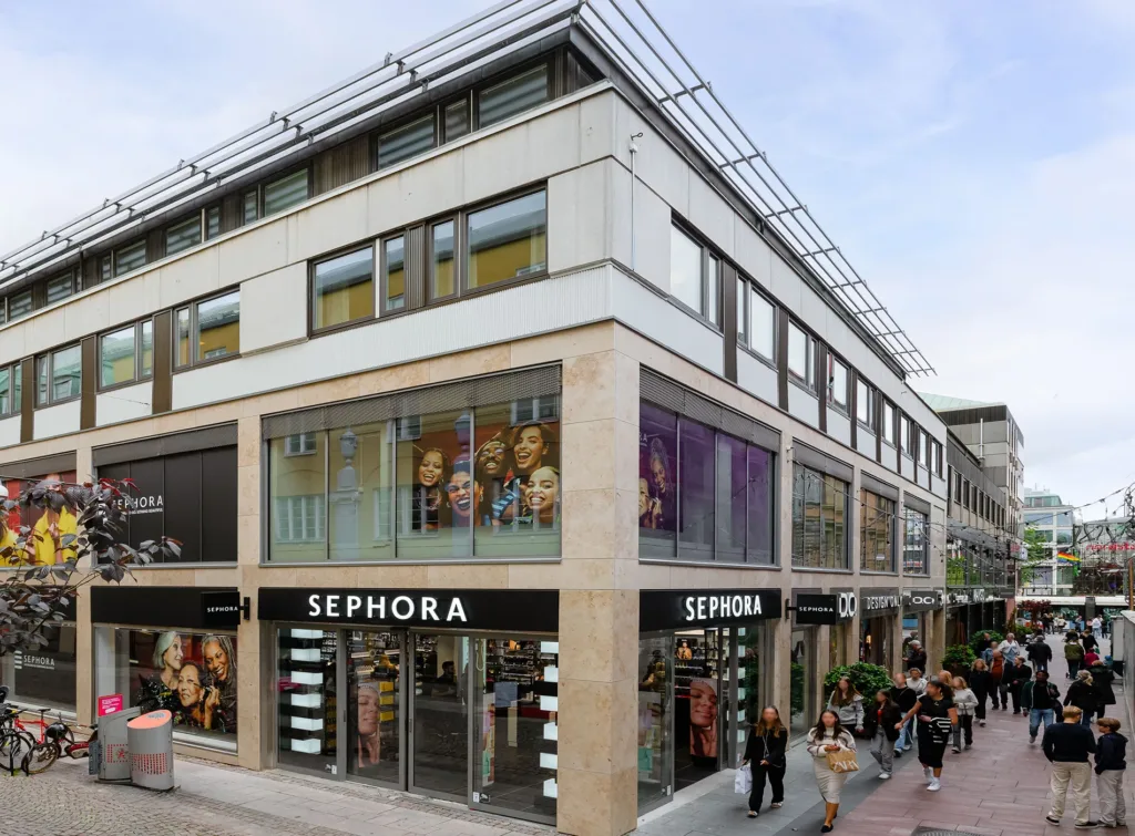 En byggnad med Sephora-butik på bottenvåningen och människor som går förbi.