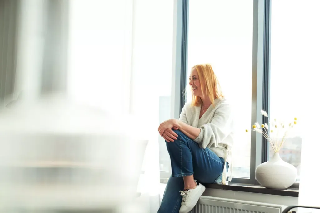 Kvinna sitter på fönsterbleck
