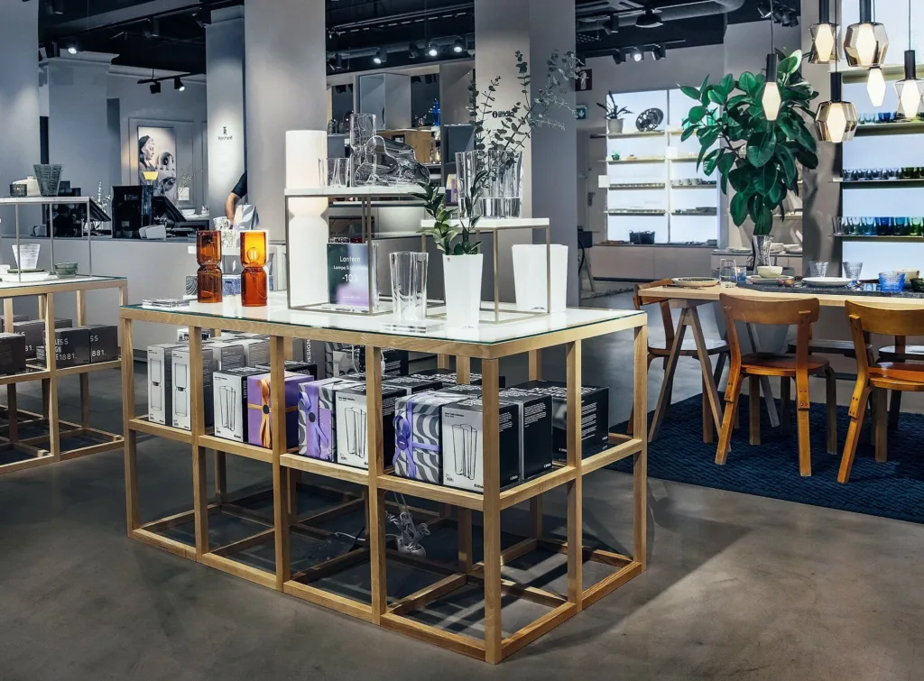 En modern butik med en trähylla fylld med produkter, dekorationer och växter.