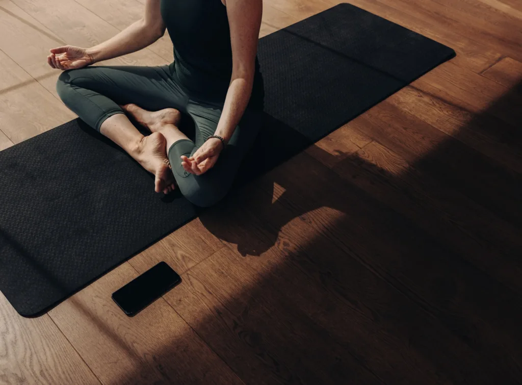 Kvinna utför yoga på yogamatta.