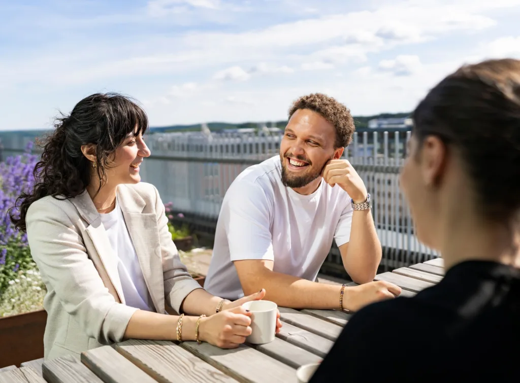 Tre personer som sitter på en takterrass