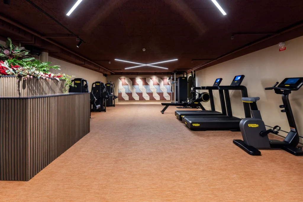 3. Ett gym med träningsmaskiner, löpband och spegelväggar under modern belysning.