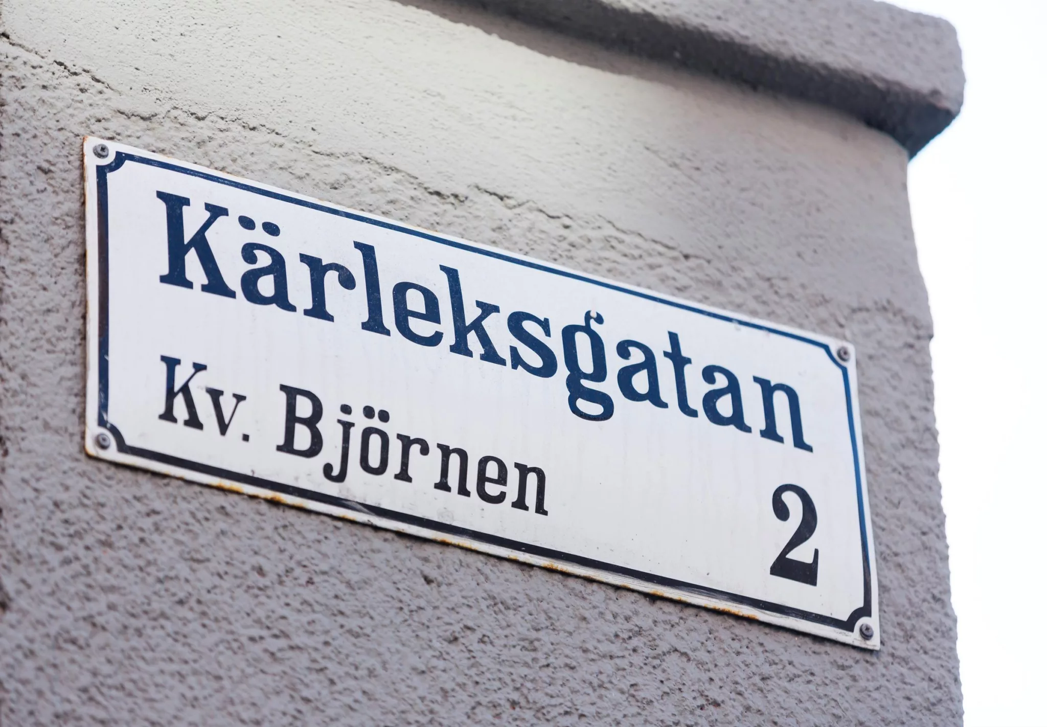 Närbild av en vit gatunamnskylt med texten "Kärleksgatan, Kv. Björnen 2".