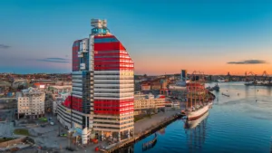 3. En färgstark byggnad och hamn med båtar under en solnedgång.