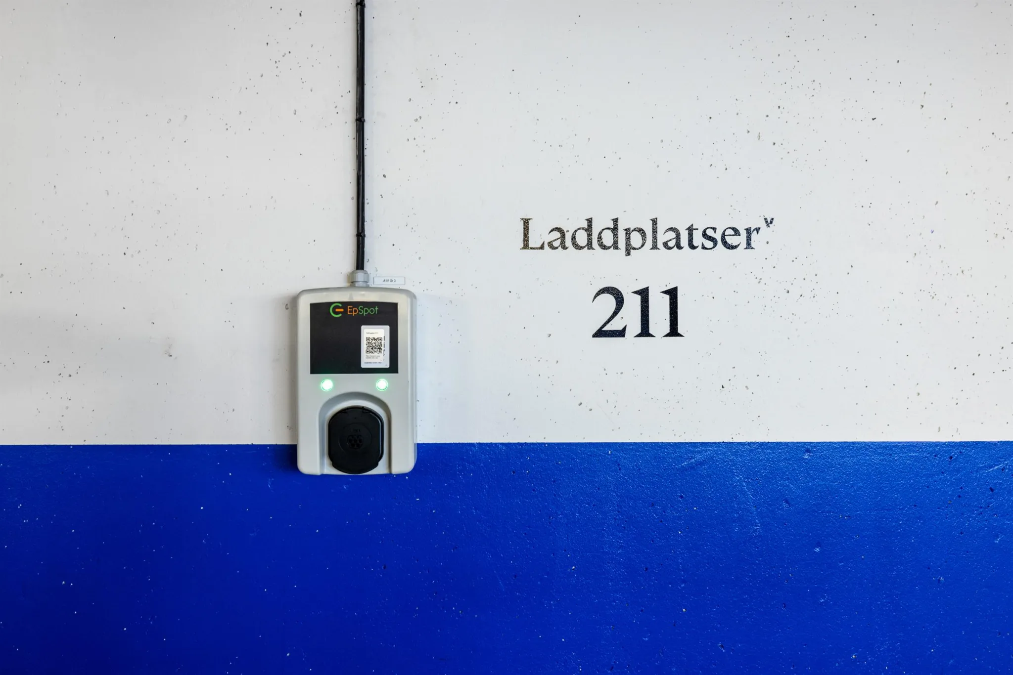 En laddstation för elbilar på en vägg med texten "Laddplatser 211".