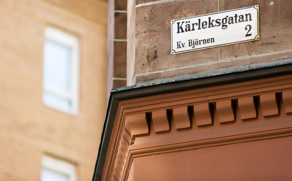 3. En gatuhörnsskylt med texten "Kärleksgatan Kv. Björnen" på en tegelfasad.