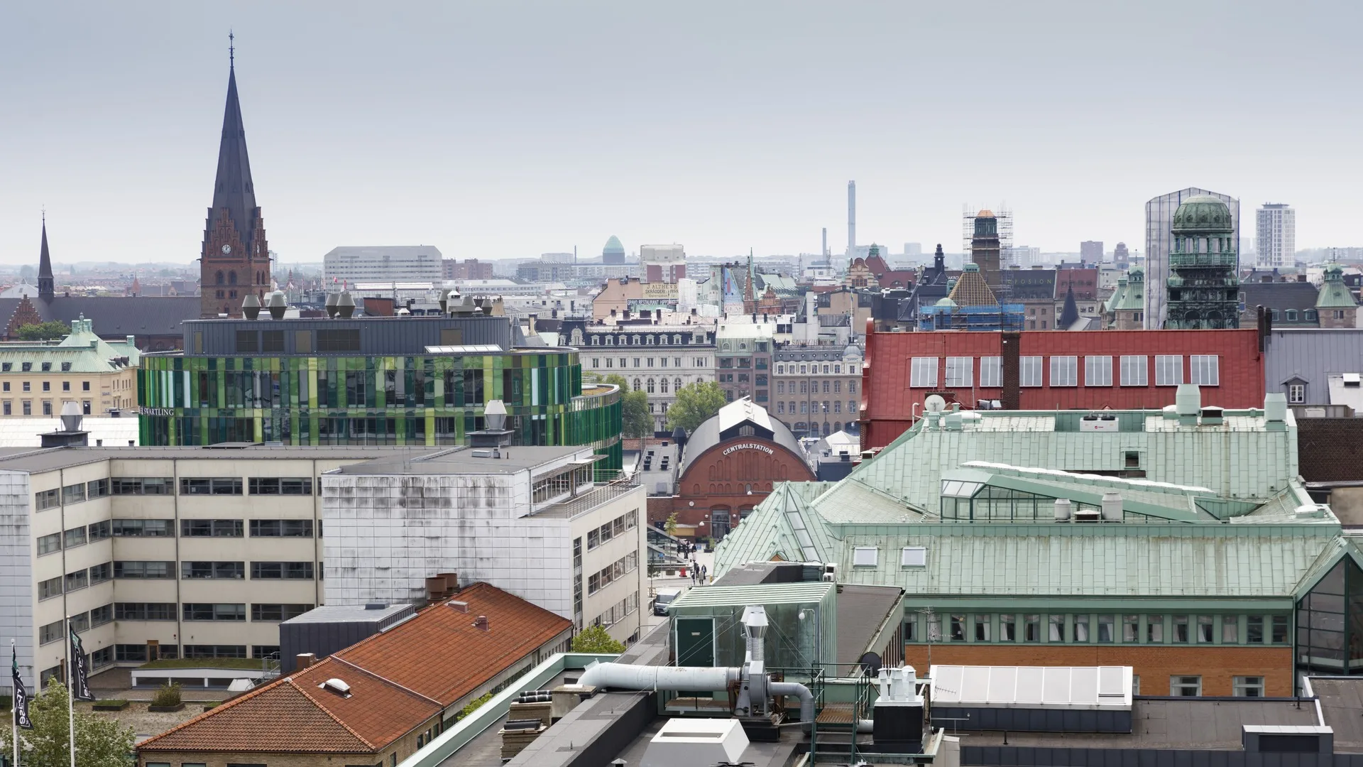 1. Vy över stadens tak med byggnader i olika färger och stilar.