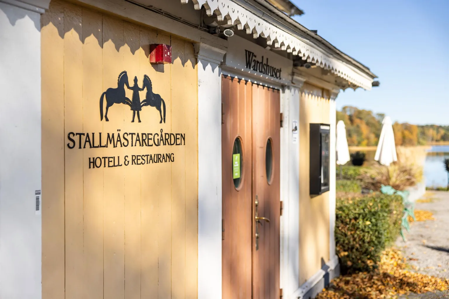 En gul byggnad med texten "Tällmästaregården Hotell & Restaurang" på fasaden.