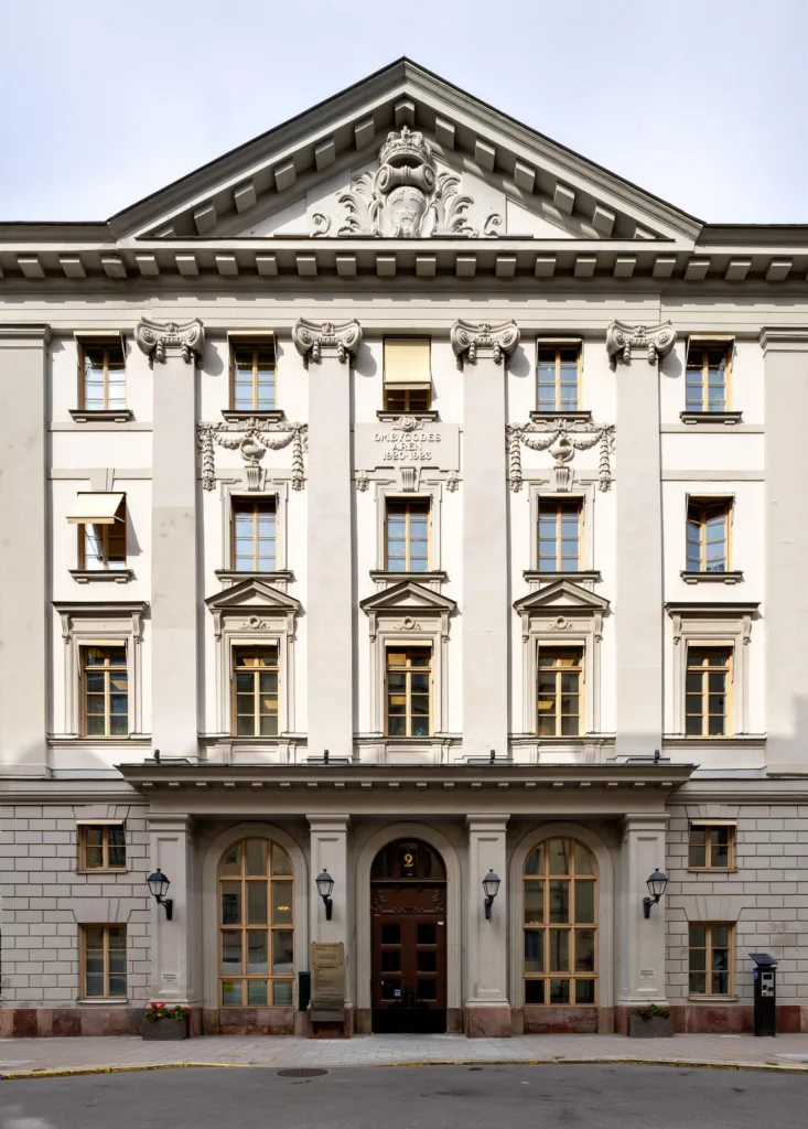 En pampig byggnad med klassisk arkitektur, hög fasad och dekorerade fönster.