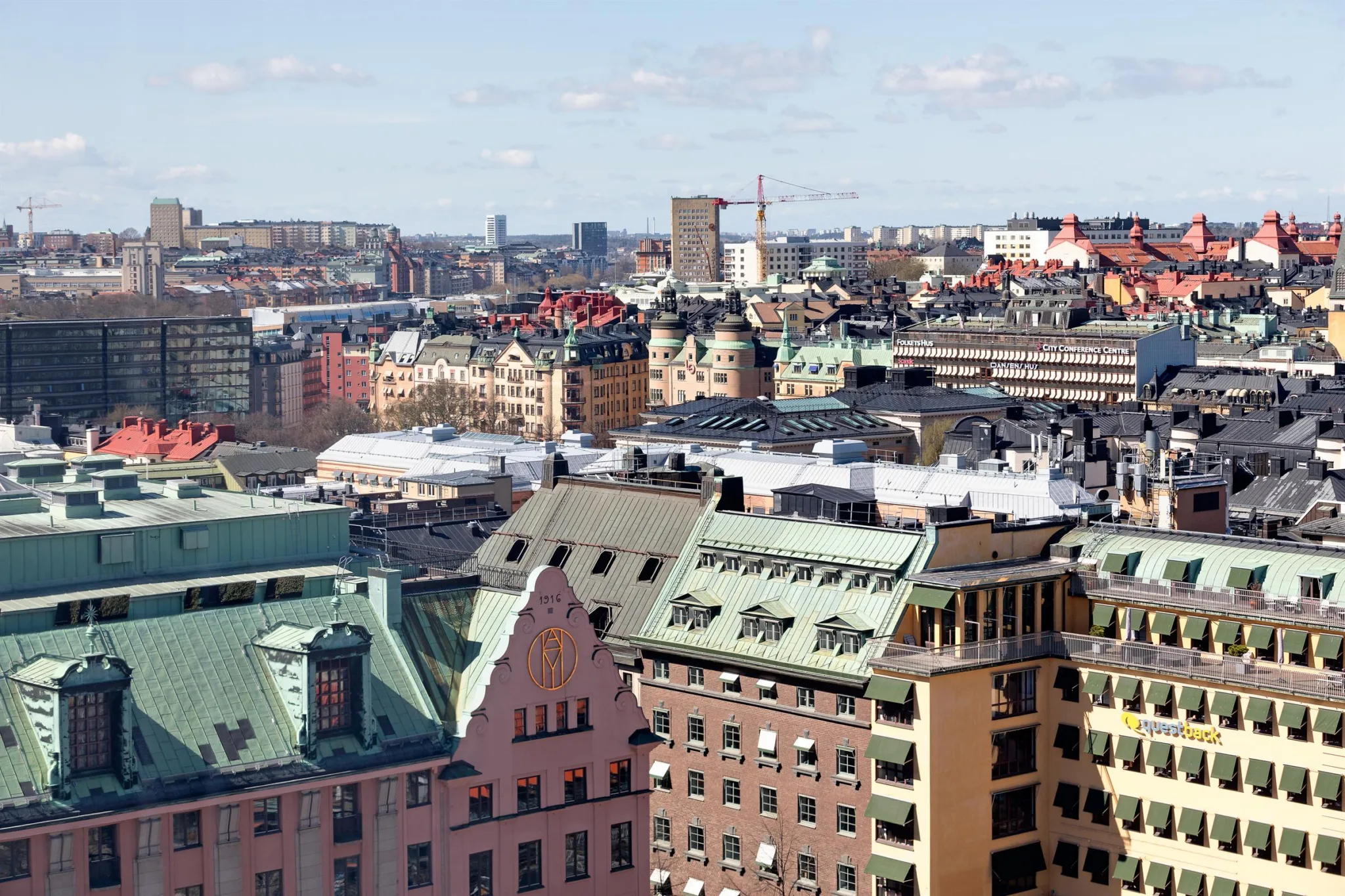 3. En stadsbild med tak av äldre byggnader och moderna höghus i bakgrunden.