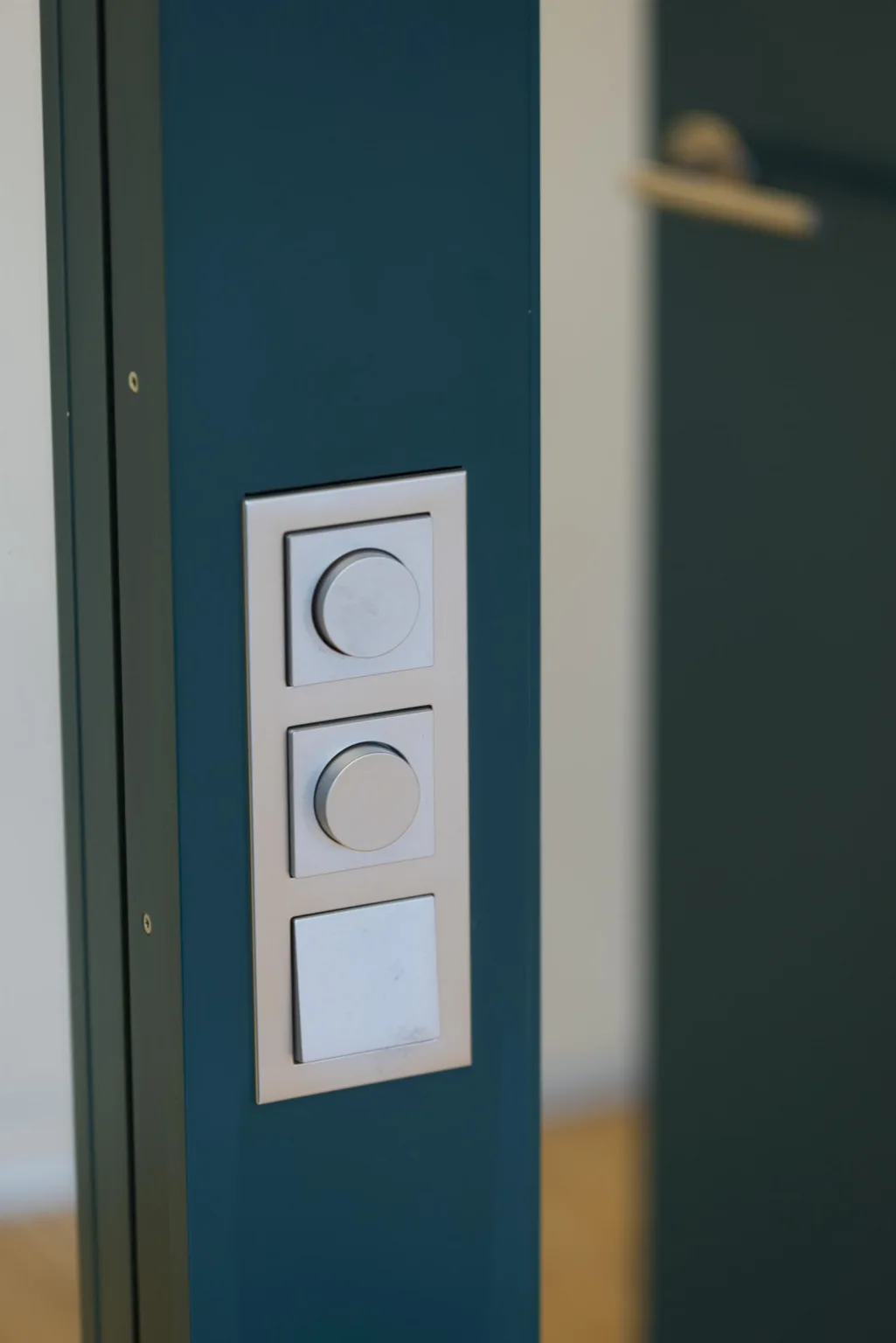 5. En vägg med tre vita strömbrytare och reglage monterade på en mörk yta.