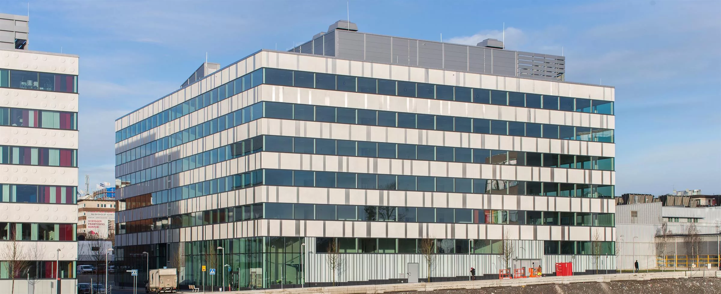 5. En fyrkantig byggnad med glasfasad och tak med en mindre struktur ovanpå.