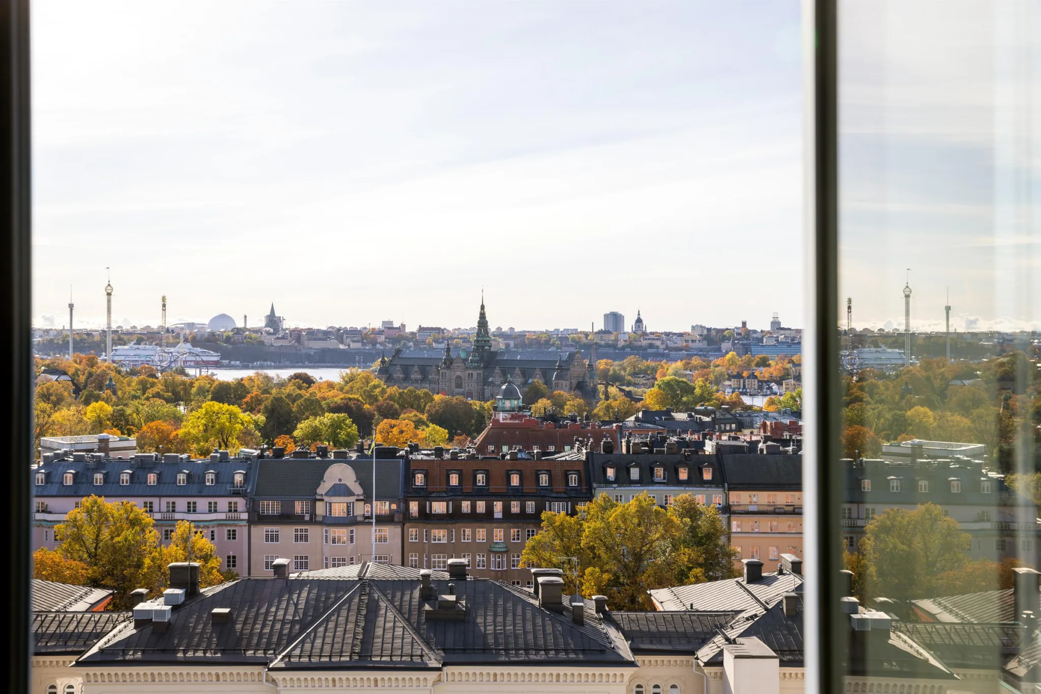 Utsikt över en stad med historiska byggnader, grönska och vattendrag.