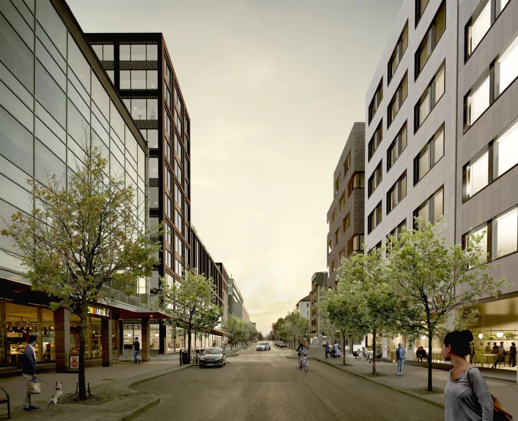 2. En stadsgata kantad av moderna byggnader och träd med gångare och bilar längs gatan.