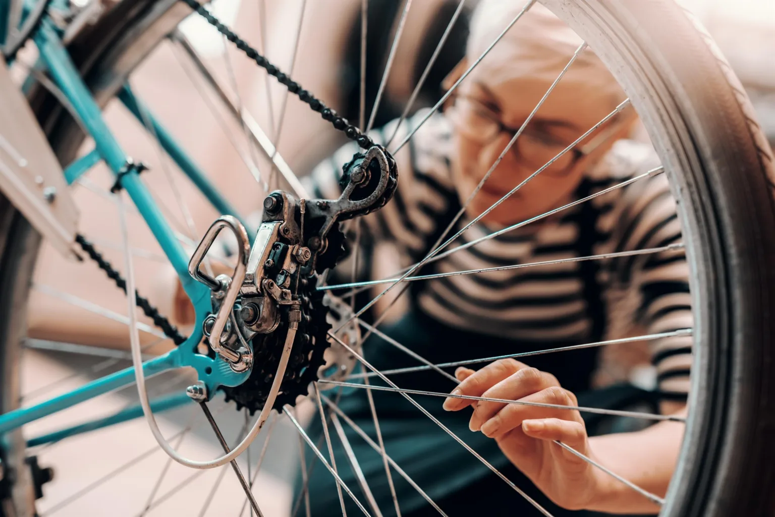 En person reparerar en cykel och fokuserar på kedjan och växlarna.