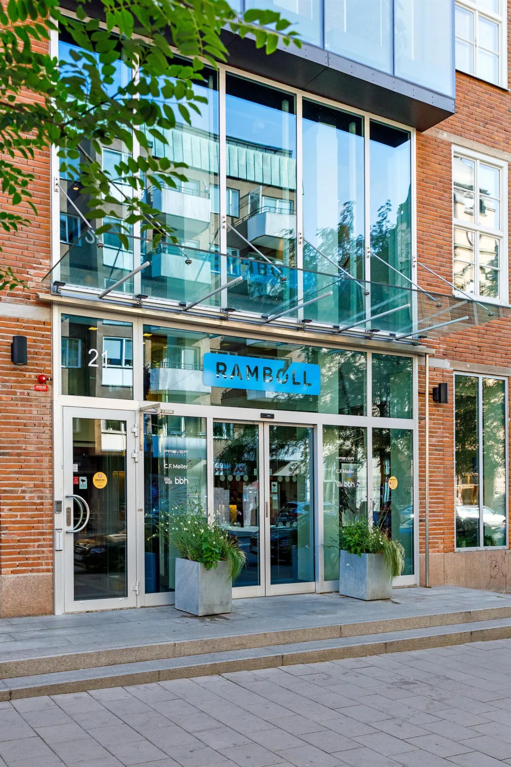 3. Entrén till en byggnad med glasfasad och texten "Campus" synlig ovanför dörrarna.