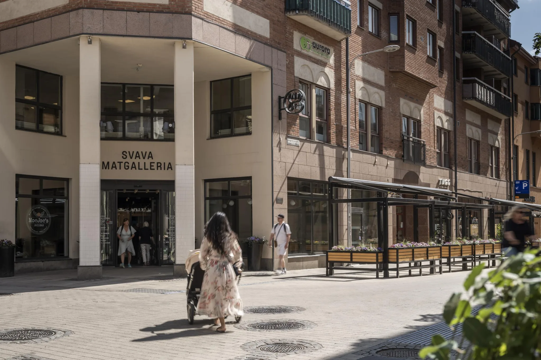 Entré till en matgalleria med människor som går framför byggnaden.