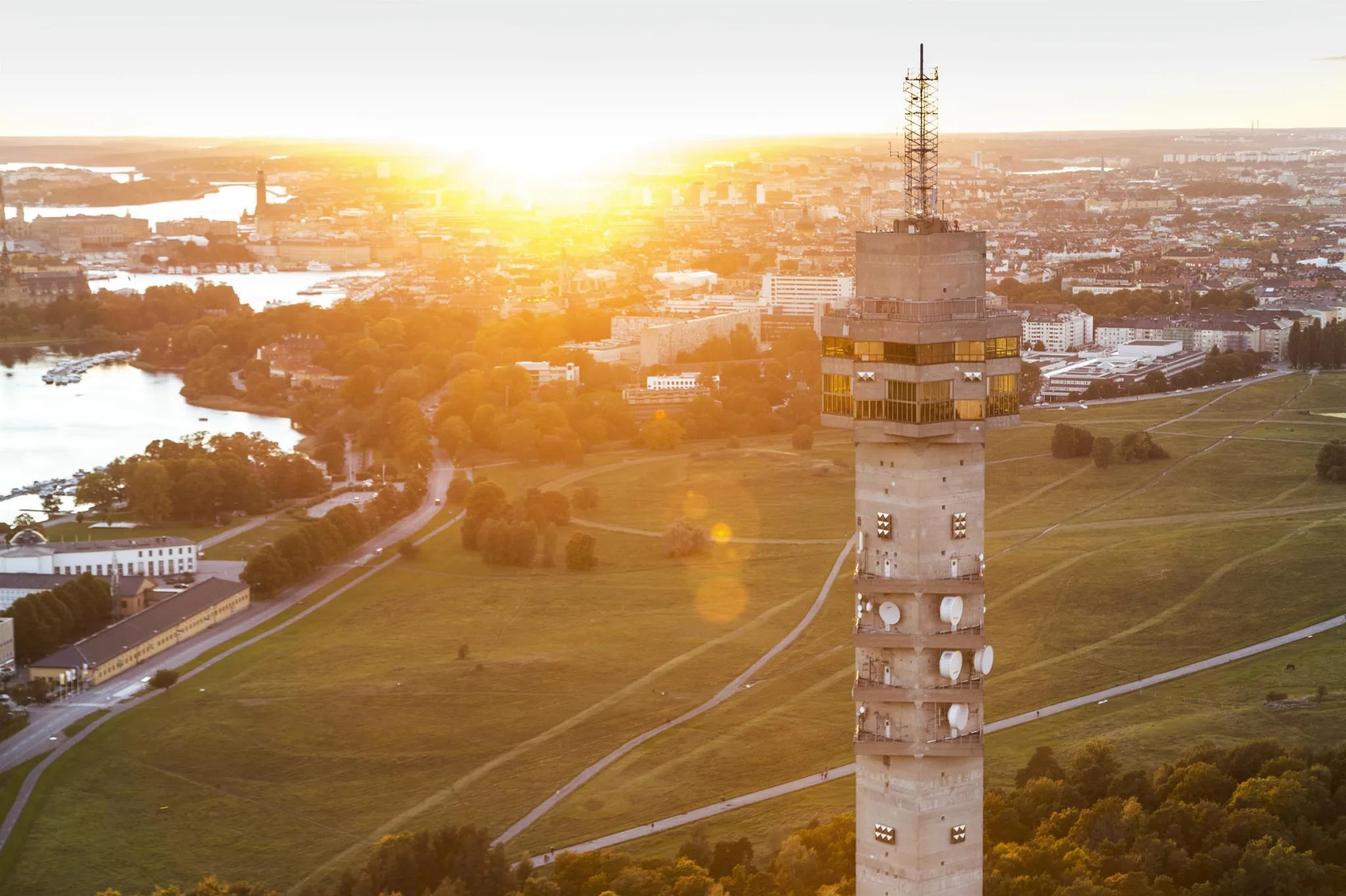 5. Utsikt över en stad med ett högt torn i förgrunden och solnedgång i bakgrunden.