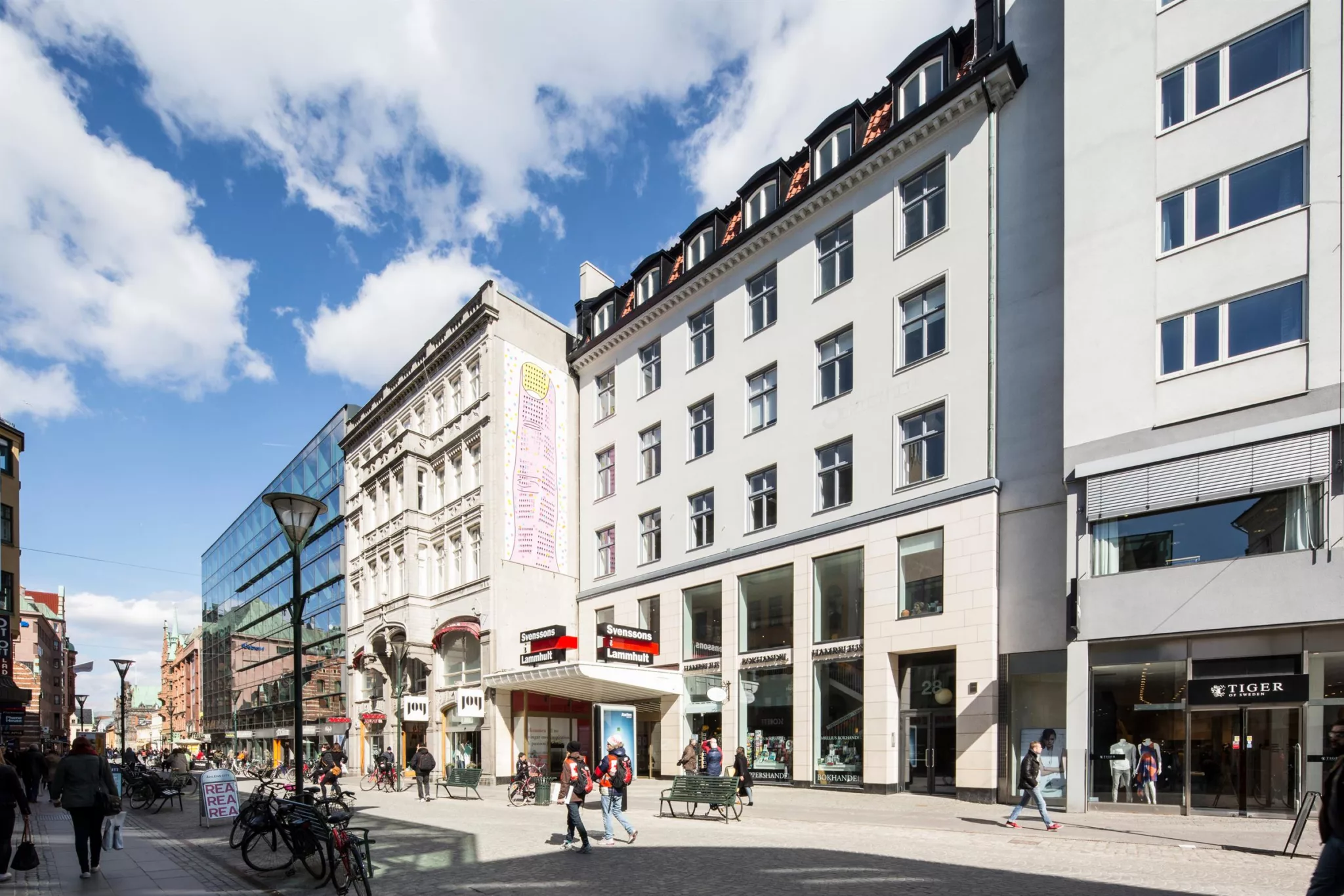5. Stadsgata med moderna och klassiska byggnader under en blå himmel.