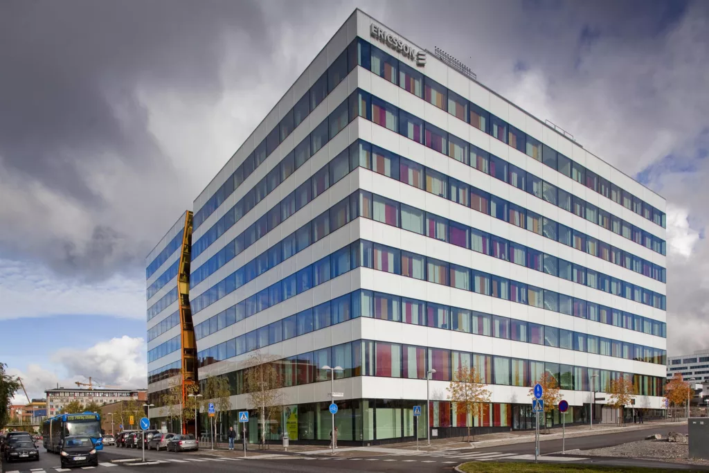 5. En stor kontorsbyggnad med glasfasad och färgade fönster, en gul skulptur står bredvid.