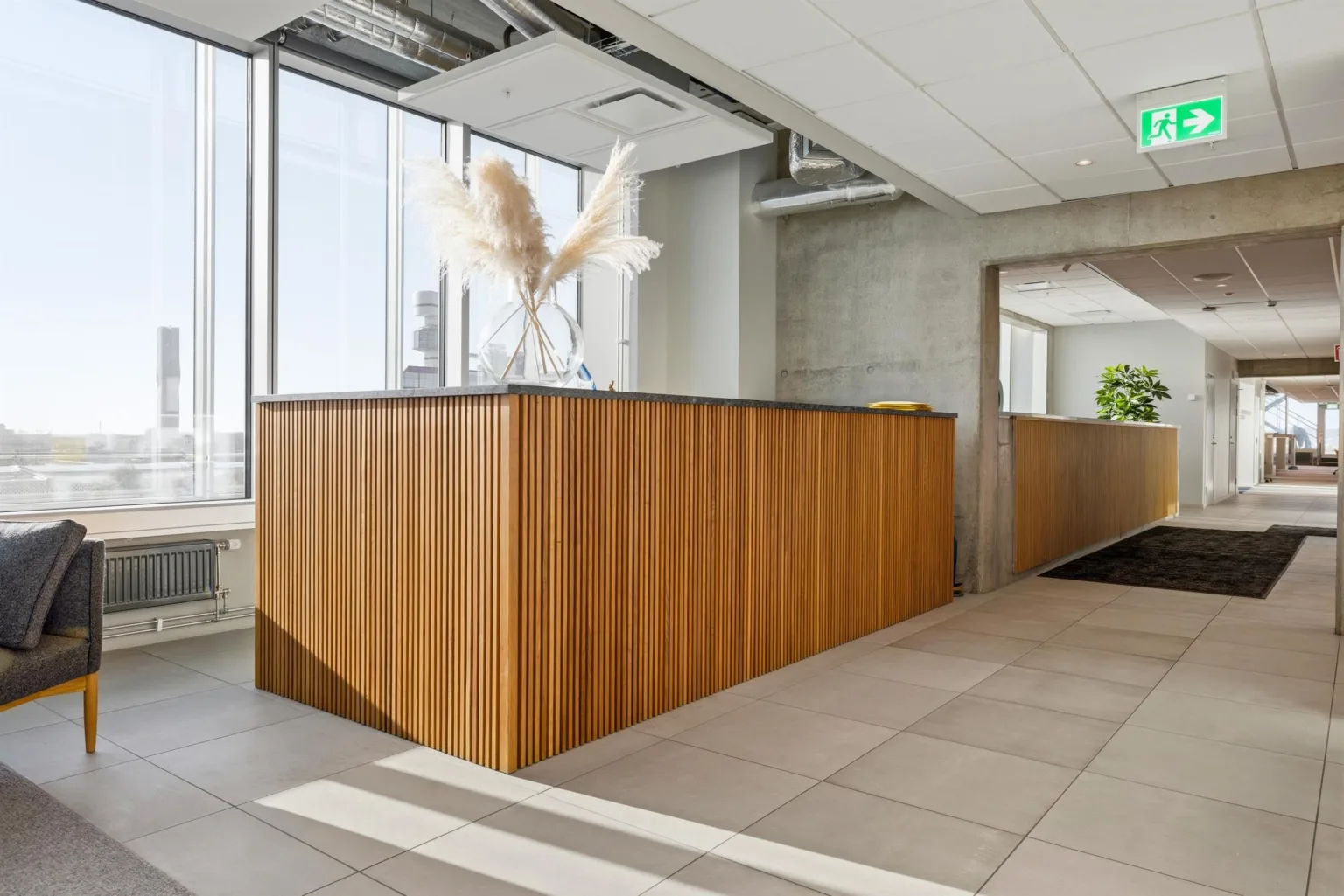 En reception med träpaneler och dekorativa torkade växter ovanpå.