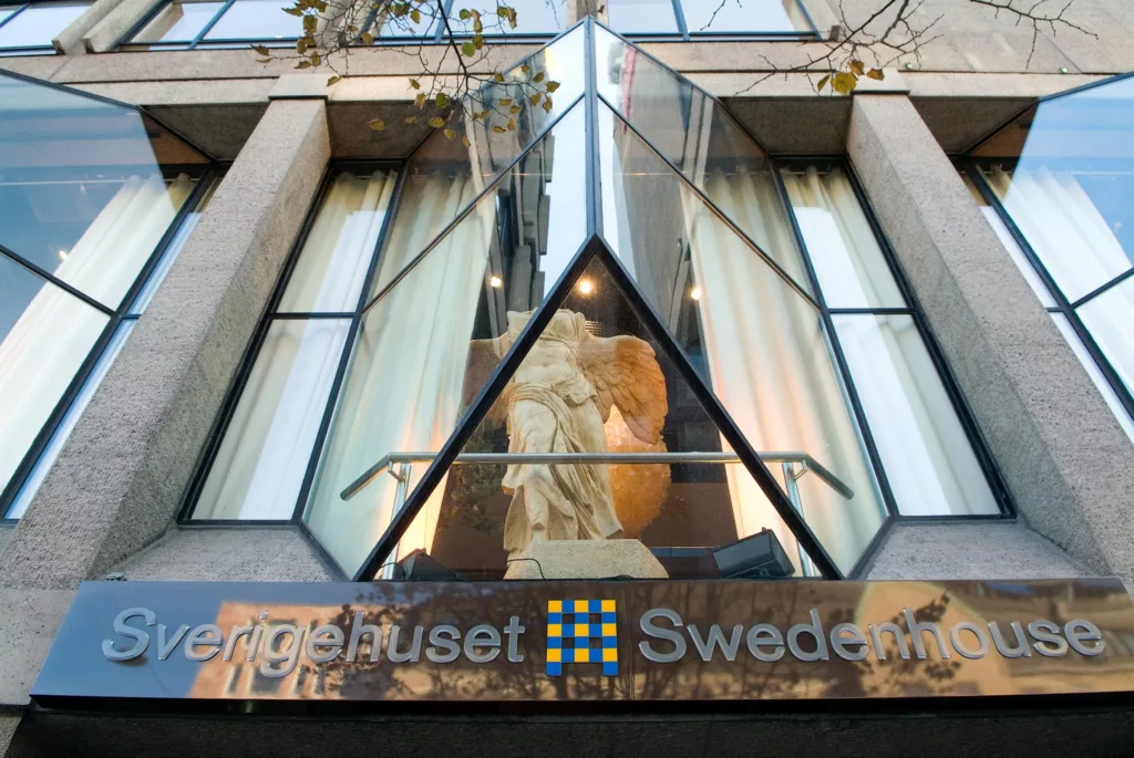 En skulptur syns genom en glasfasad med texten "Sergelhuset Swedbank" under.