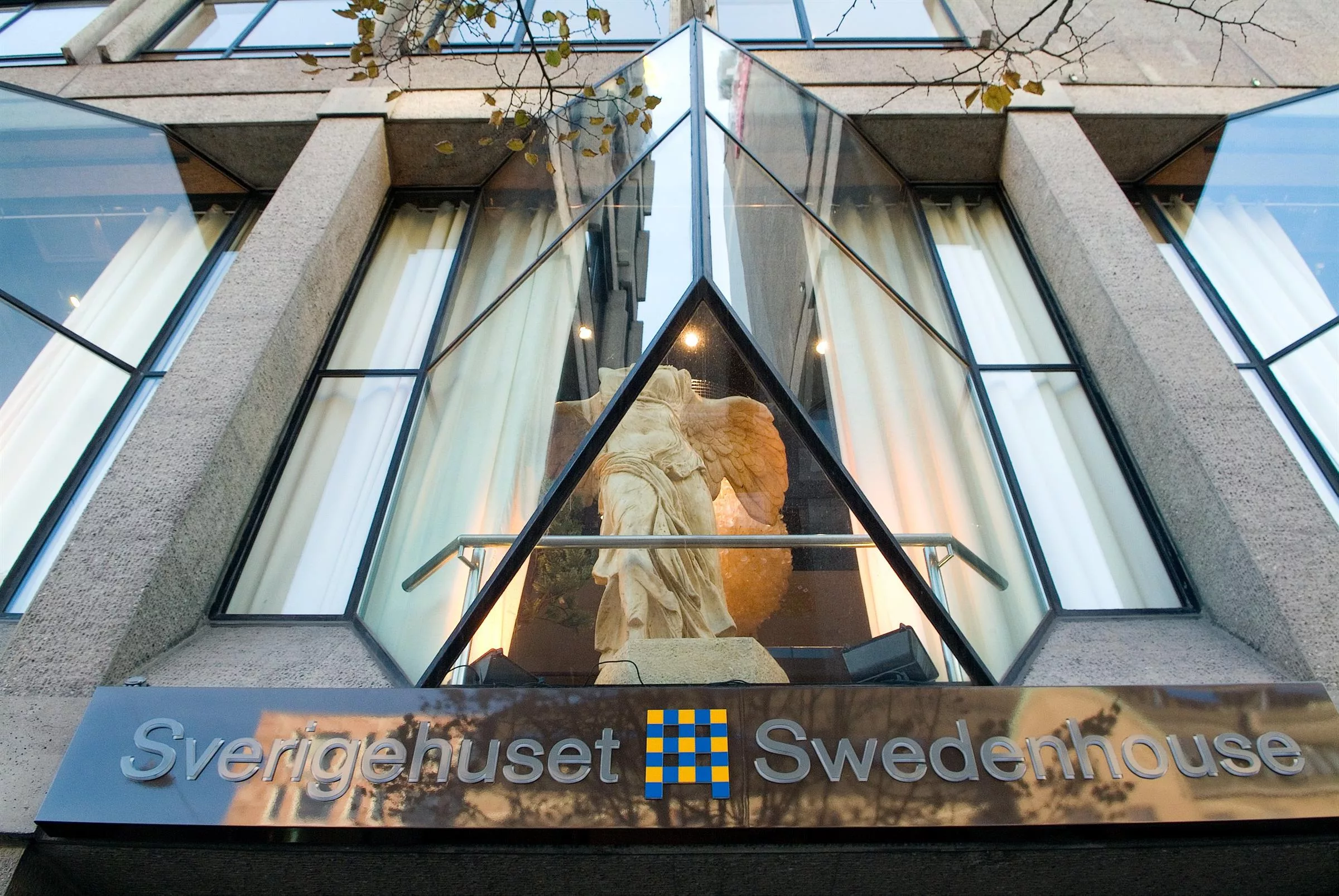 En skulptur syns genom en glasfasad med texten "Sergelhuset Swedbank" under.