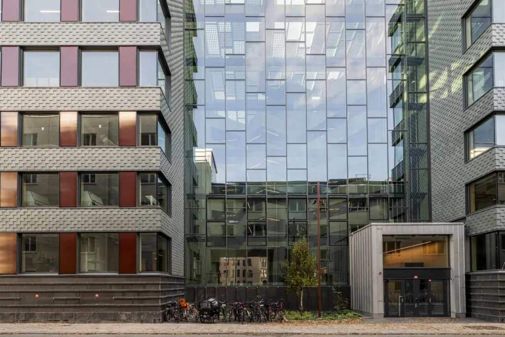 En modern byggnad med glasfasad och cyklar parkerade framför.