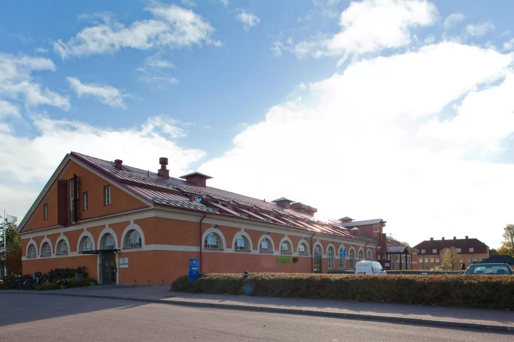 2. En lång orange byggnad med välvda fönster och takfönster på en solig dag.