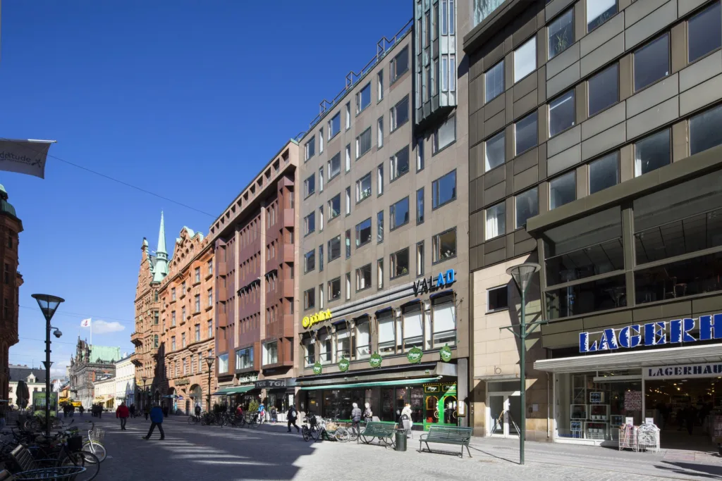4. En gata med moderna och äldre byggnader i olika färger under en klarblå himmel.