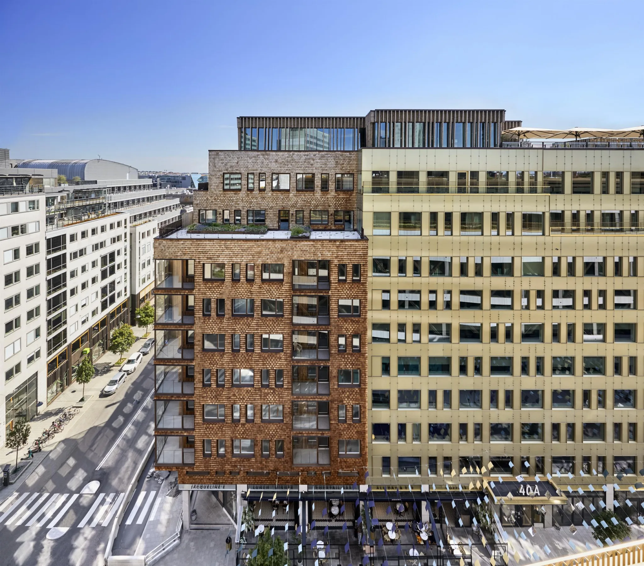 Flera byggnader med varierande fasader, soligt väder och stadsmiljö.