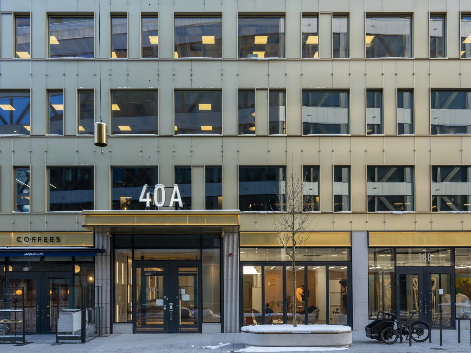 En byggnad med adressen 40A, stora glasfönster och ett modernt fasadutseende.