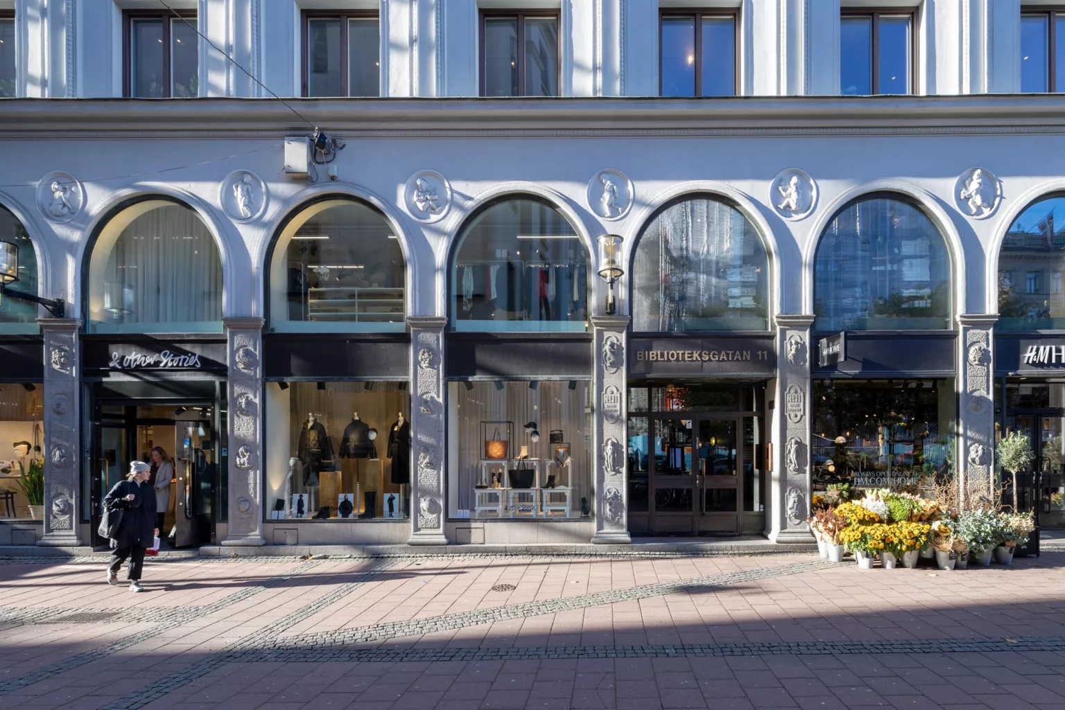 4. En rad butiker med glasfasader och skyltar längs en trottoar.