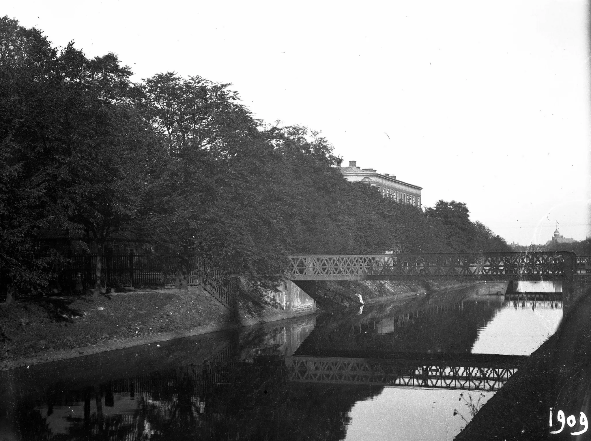 3. En svartvit bild av en flod med en bro och träd längs flodens kant.