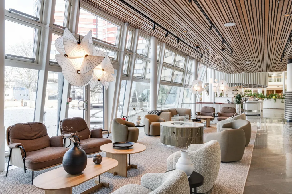 1. En modern lounge med stora fönster, bekväma sittmöbler, designlampor och ett träbeklätt tak.