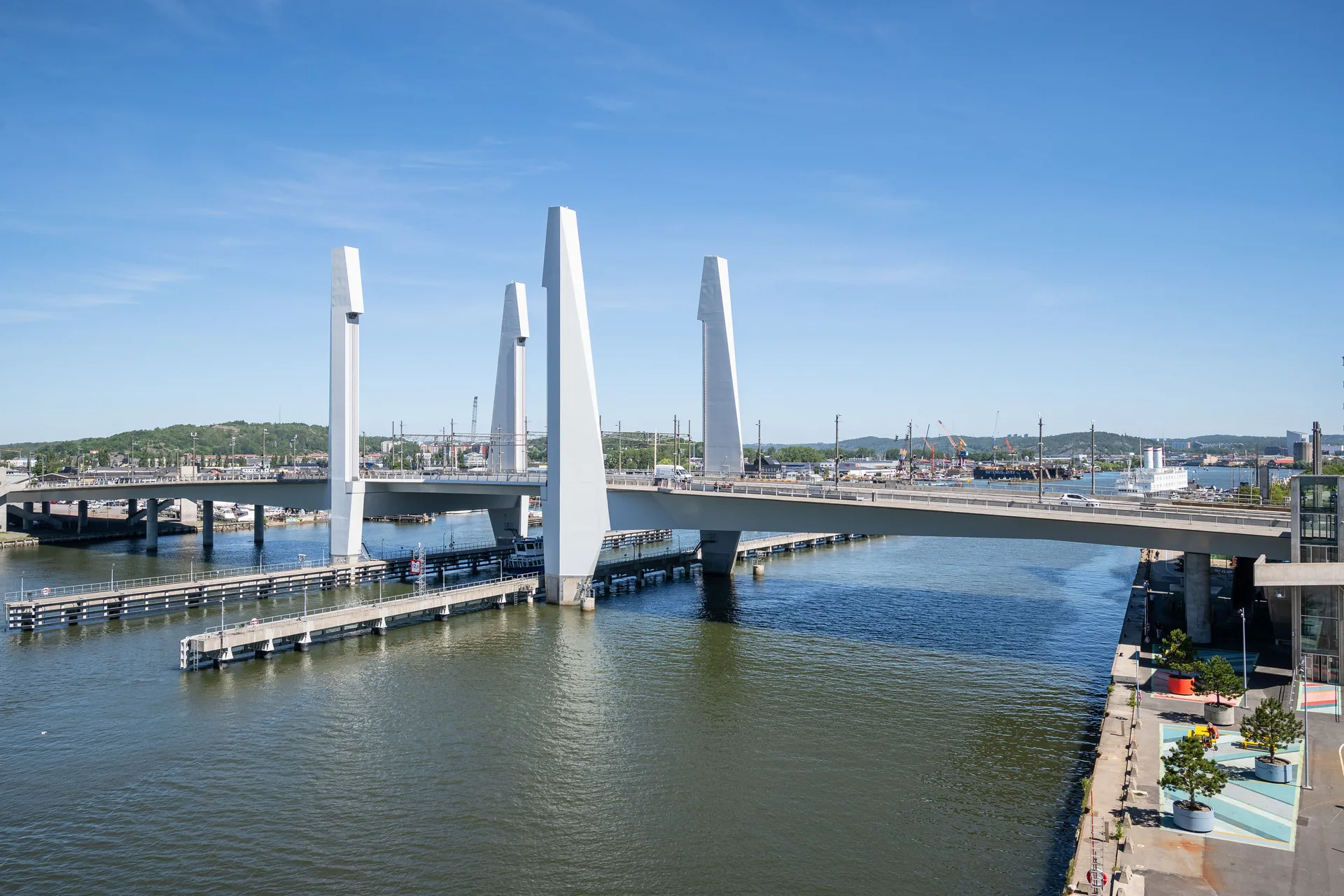 3. En modern bro med höga pelare som sträcker sig över en vattenkanal under en klarblå himmel.