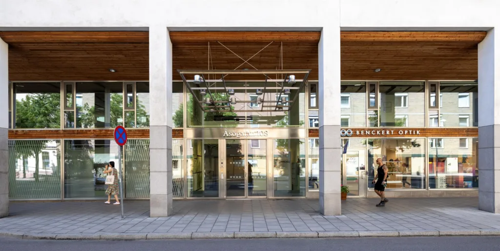 3. En modern byggnad med glasfasad och trädetaljer, reflekterande stadsmiljö i glaset.