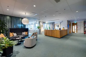 5. En reception med en trädisk, sittgrupp med soffor och bord, samt dekorativa element som en stor lampa och växter.