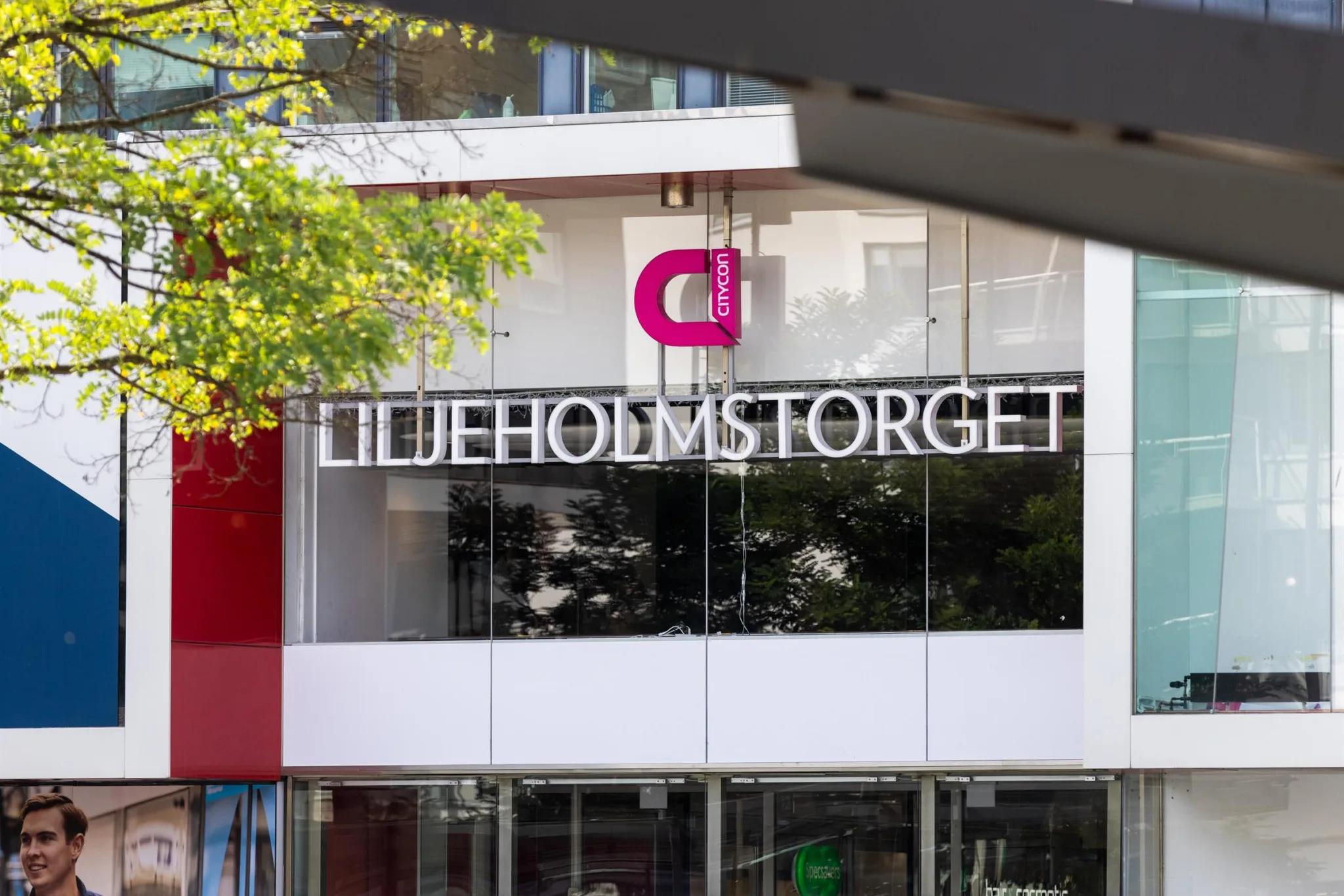 Fasaden till Liljeholmstorget med texten "Liljeholmstorget" och en rosa logotyp.