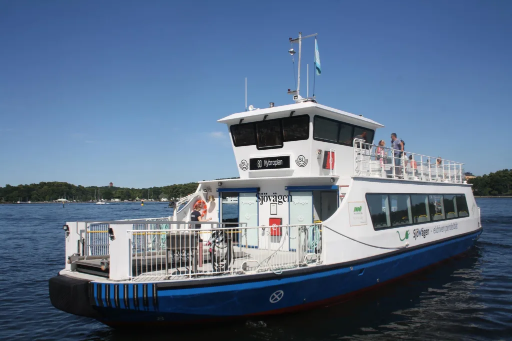2. En vit passagerarbåt ligger vid en brygga under en klarblå himmel.