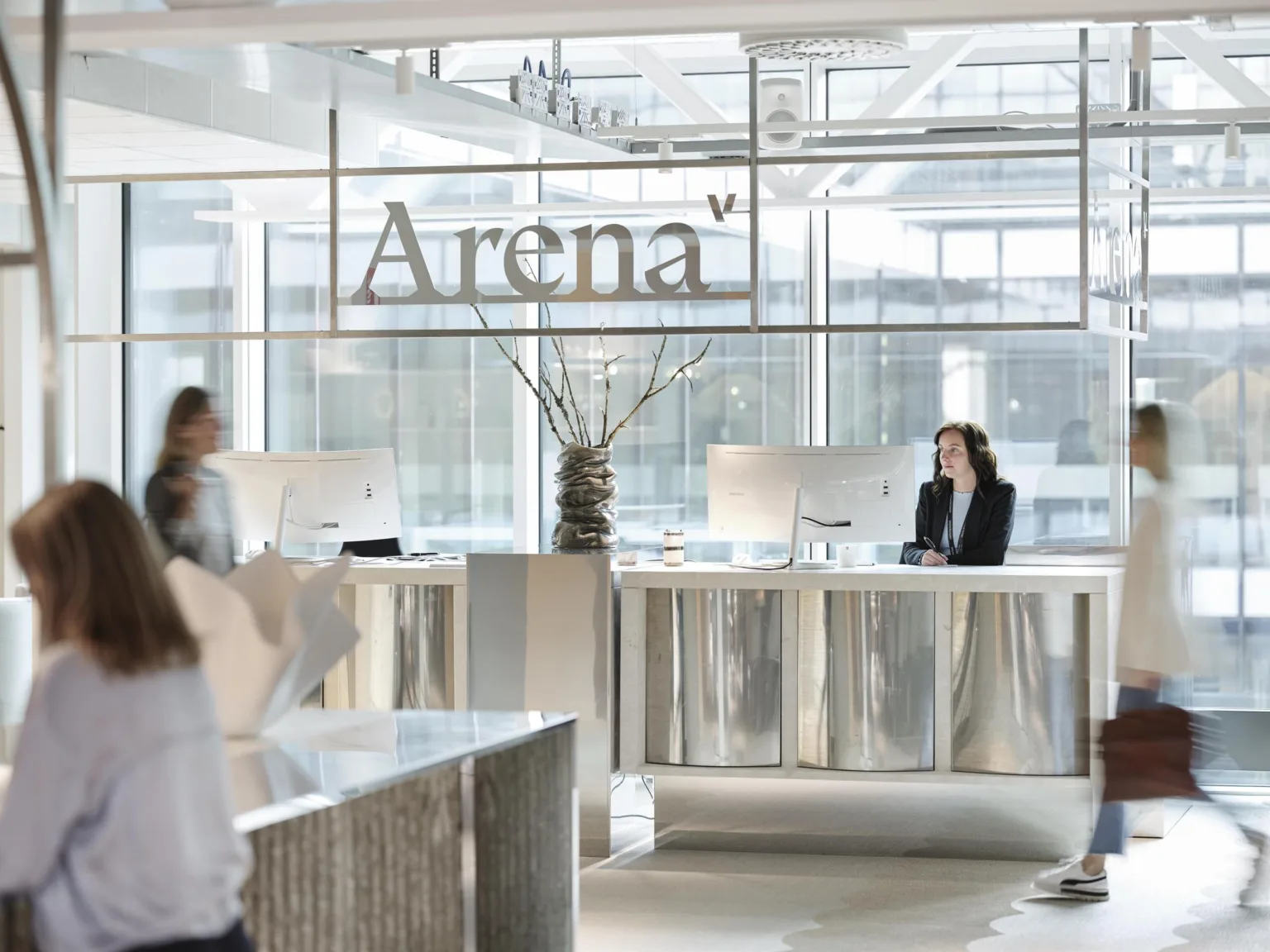En reception med skylten "Arena" ovanför, där en kvinna sitter vid en disk.