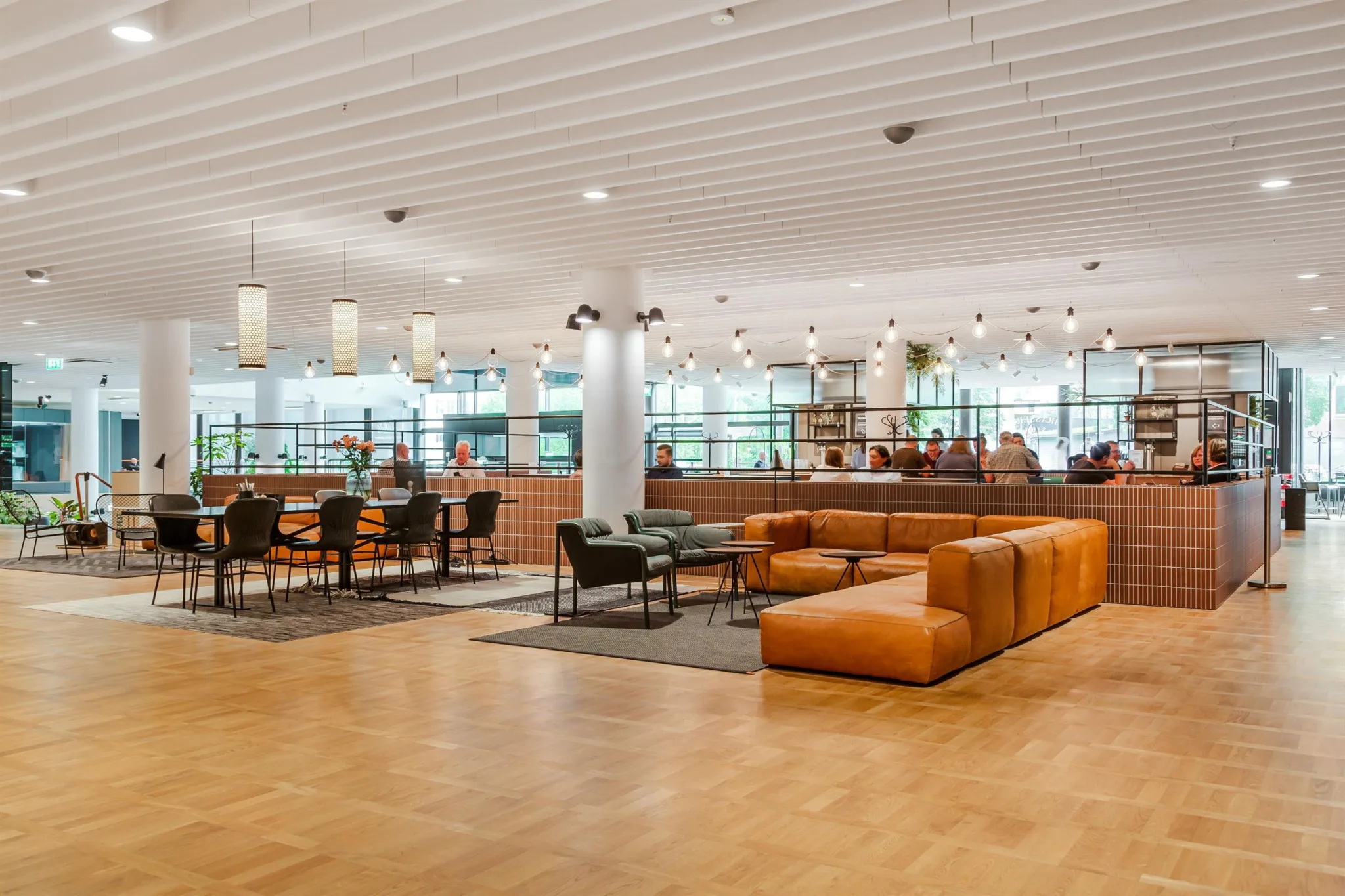 Ett öppet loungeområde med soffor, fåtöljer och bord i en inbjudande miljö.