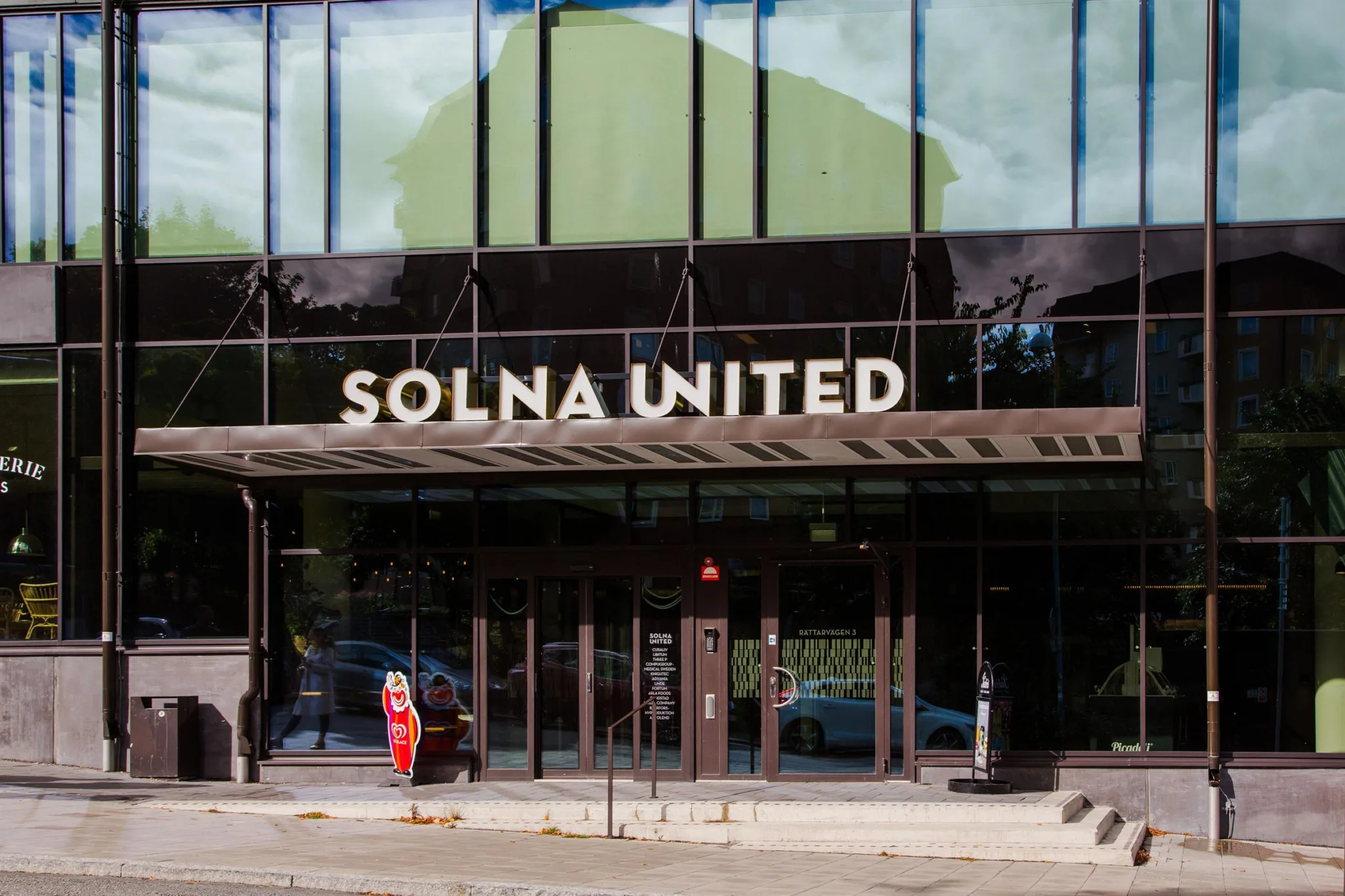 Entrén till Solna United med stora glasfönster och texten "SOLNA UNITED" ovanför.