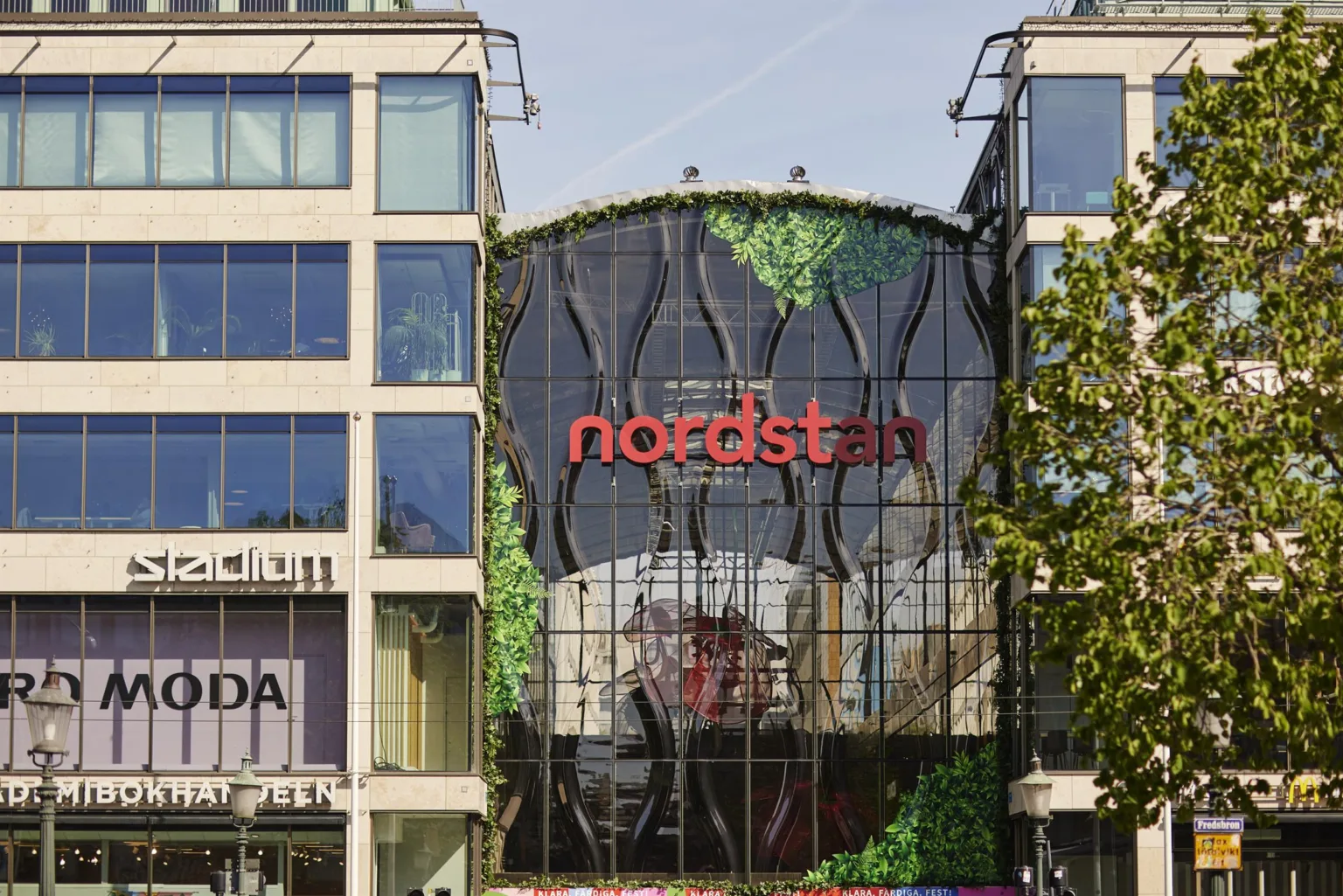 Fasaden av köpcentret Nordstan med texten "nordstan" och gröna växtdekorationer.